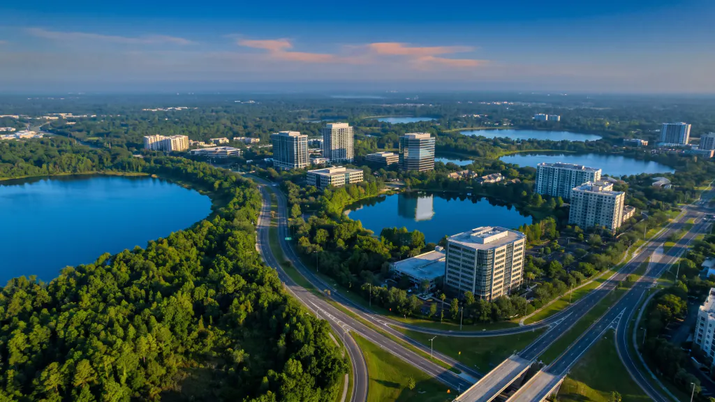 Aerial of mid-rise buildings among lakes and trees in Central Florida.